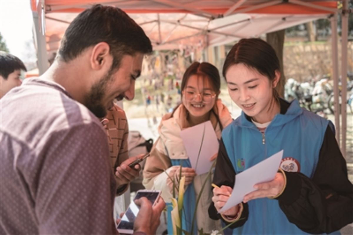 365英国上市集团本禹志愿服务队及各分队在荟园365社区深入开展“学雷锋”活动暨公益嘉年华，张瑜服务队志愿者向留365介绍花卉种植知识